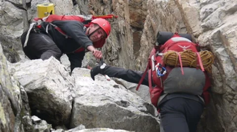 Alpine climbers helping each other with teamwork on the rock Stock Footage