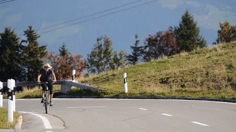 Alpine cyclist riding uphill Video stock 111292593