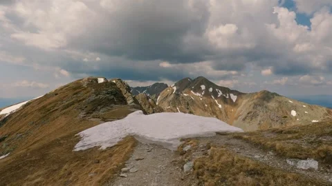 Alpine Hiking Trail in Early Spring With Snow and Dramatic Stormy Clouds Stock Footage 309653692
