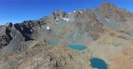 Alpine Lake - Red Rocks And Turquoise Water - Aerial View 4K Stock Footage