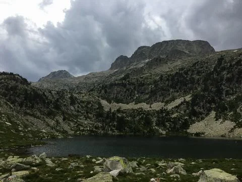 Alpine lake reflecting cloudy sky in mountains 写真素材