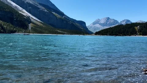 Alpine lake view with mountain peaks, blue water surface, hiking trail, travel d Vídeo Stock 345682777