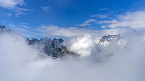 Alpine landscape. High mountains in the clouds. Stock Photos