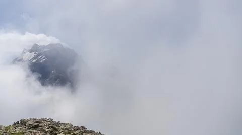 Alpine landscape. High mountains in the clouds. Stock Photos