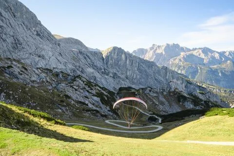 Alpine landscape with hovering paraglider Stockfoto's