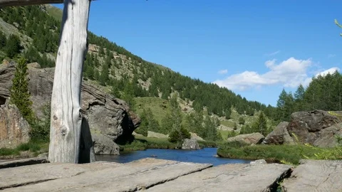 Alpine landscape with small river flowing and wooden bridge. Stock-Footage 79580100