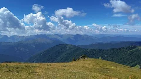 Alpine meadow vista, mountain ranges layered horizon, daytime aerial panorama Stock-Footage 347349403