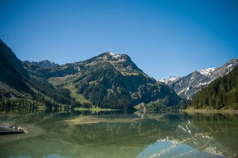 Alpine Mountain Lake With Clear Reflection, Snow-Capped Peaks, Pine Forest .. Stock Photos