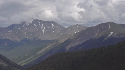 Alpine mountain pass,   Snow capped peeks in the distance. 動画素材 117540832