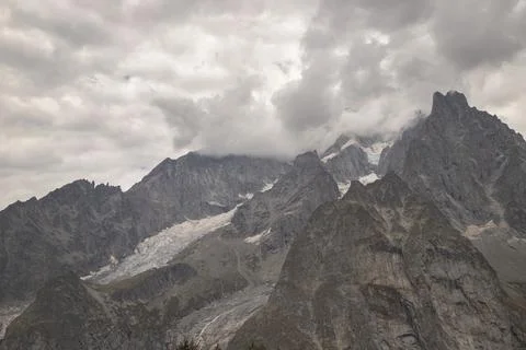 Alpine mountain range with glaciers and cloudy sky Stock Photos