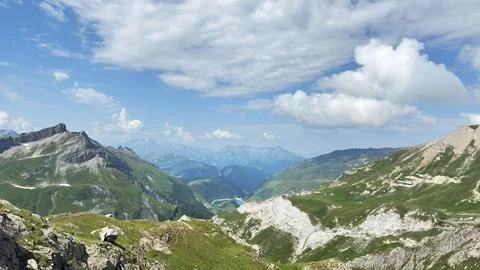 Alpine Mountain Range Green Valley Fluffy Clouds Blue Sky Panorama Foto stock