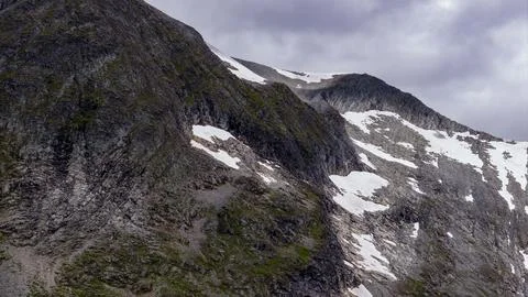 Alpine mountain ridge with snow patches and exposed rock faces, Rauma Norway Foto stock