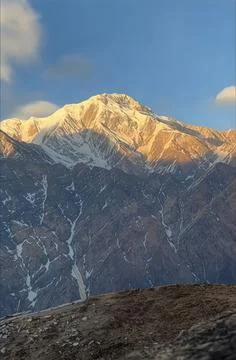 Alpine mountain summit with snow channels and rocky ridges in morning light Stock Photos