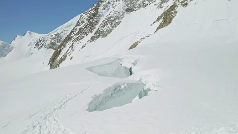 Alpine panorama, deep collapsed hollow in thick snow at foots of huge mountain Stock Footage 126363873