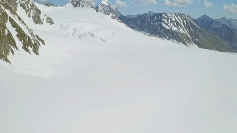 Alpine panorama, expedition wade over broad mountain slope full of eternal snow Stock Footage 126365645
