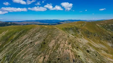 Alpine ridge with summit cross under blue sky, Romania Stock Photos