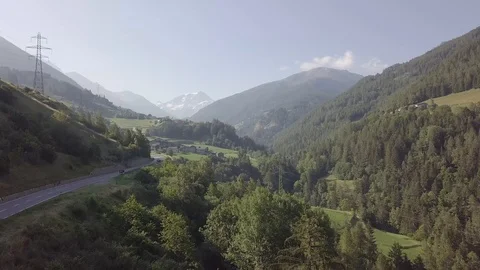 Alpine road on top of the mountain and green trees everywhere Stock Footage