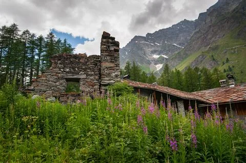 Alpine ruins of stone structures made of dark stone and wood  Foto stock