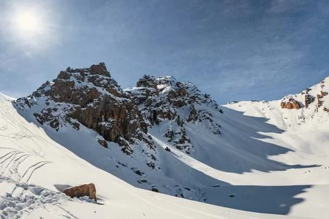 Alpine Serenity: Cold winter sunlight dances on three rocky peaks, creating Stock Photos