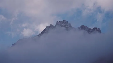 Alpine Snowy Summit Emerging from Mist Stock Footage 320601236