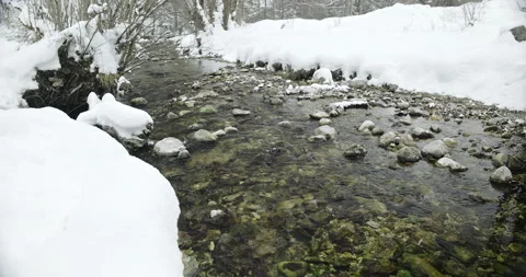 Alpine stream approaches waterfall in winter season Stock Footage 231732348