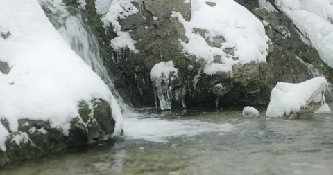 Alpine stream passes through frozen rocks Stock-Footage 231732799