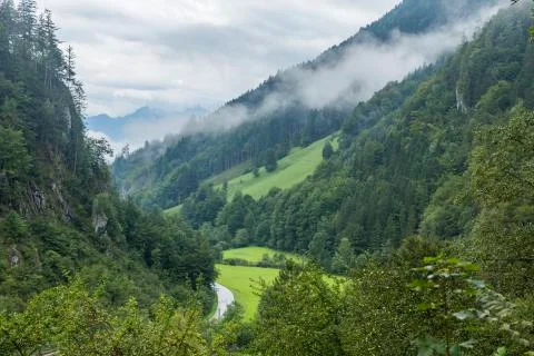 Alpine valley after rain with the clouds raising Stock Photos