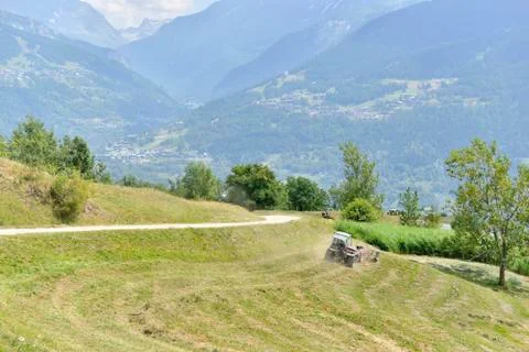 Alpine valley and tractor Stock-Fotos