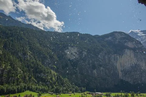 Alpine valley seen through sunlit water drops, inside Staubbach waterfall Stock Photos
