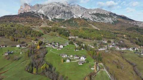 Alpine village under a mountain range in the center of a valley. Stock Footage 221188084