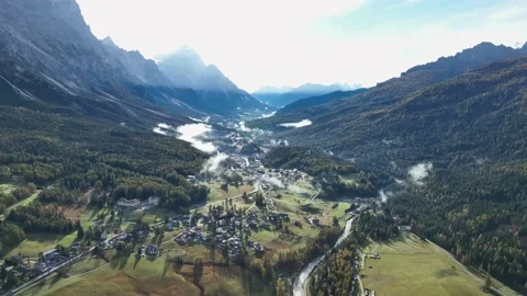 Alpine village under a mountain range in the center of a valley. Stock Footage 221188390