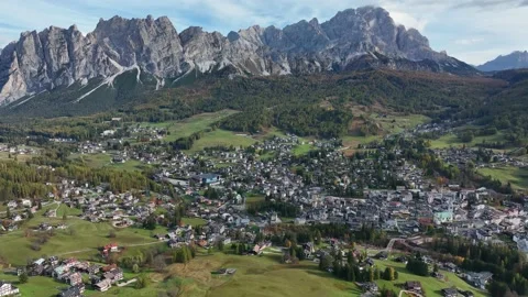 Alpine village under a mountain range in the center of a valley. Stock Footage 221188399
