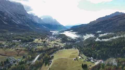 Alpine village under a mountain range in the center of a valley. Stock Footage 221188646