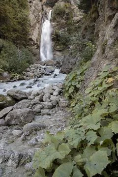 Alpine waterfall flowing down rocky mountain stream Stock Photos