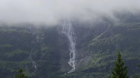 Alpine waterfall in the mountains on a cloudy misty day Stock Footage 212650068