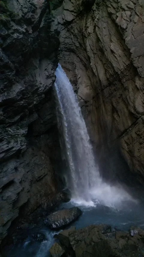 Alpine Waterfall in Narrow Gorge with Tall Cliff Walls – 4K Vertical Video stock 328706193