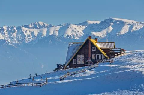 Alpine winter scenery with rustic chalet Stock Photos