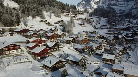 Alpine Winter Sunshine: 4K Drone Video of Grindelwald Homes, Switzerland Stock Footage 246609028