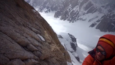 Alpinist abseiling down a snowy mountain slope Stock-Footage 335089913