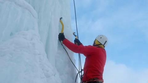 Alpinist man with ice tools axe climbing a large wall of ice. Stock-Footage 139290943