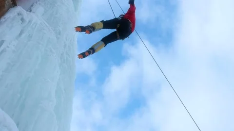 Alpinist man with ice tools axe climbing large wall of ice. going down in rope Stock Footage 146501690
