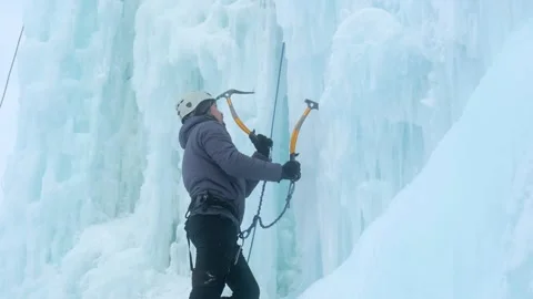 Alpinist man with ice tools axe climbing a large wall of ice. Stock Footage 150073592