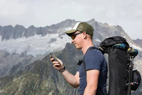 Alpinist is oriented with a GPS device in the terrain Foto stock
