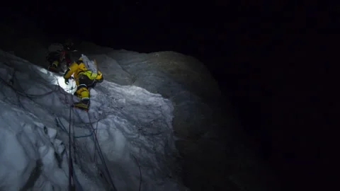 Alpinists climbing a dangerous icefall on Mount Everest at night Stock Footage 331263559