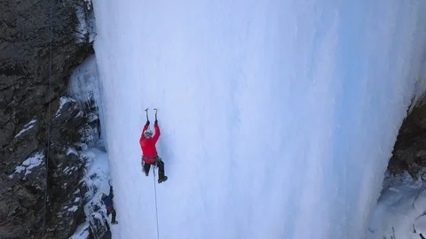 Alpinists use axe tools to climb to frozen waterfall. Aerial shot. Stock-Footage 104209148