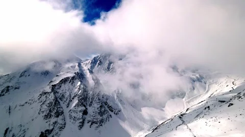 Alps | Bird flight under the clouds near the ski resort Stock Footage 255728248
