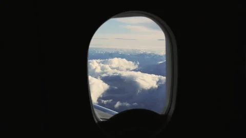Alps Majesty: Flying Over Clouds from a Plane Window Stock Footage 337578919