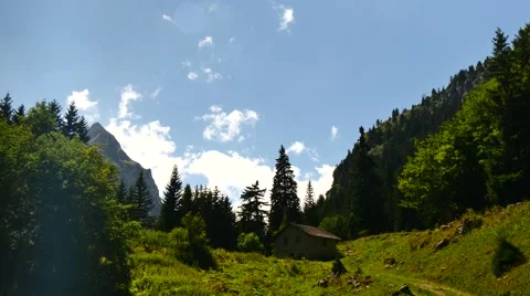 Alps montains clouds shadows small chalet swiss large shot Stock Footage 54542157