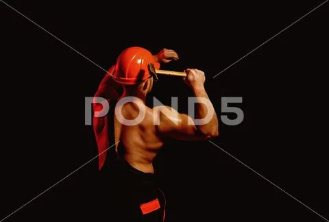 Already under construction. Construction worker hammer a nail. Muscular man Stock Photos