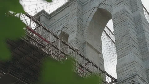 Alt closer low angle view of Brooklyn Bridge tower framed by fluttering leaves Stock Footage 340862722